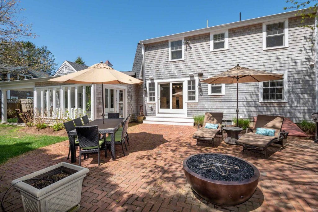 Indoor-Outdoor Living Hub Brick Patio With Dining, Lounging And Fire Pit Areas Katama Farmhouse For Sale Martha's Vineyard Real Estate